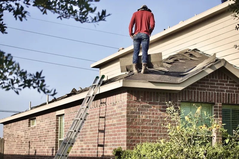 Professional roofer working on a residential roof in Cos Cob